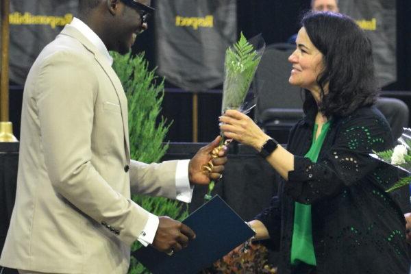 A man receiving a diploma from a woman at a graduation ceremony.